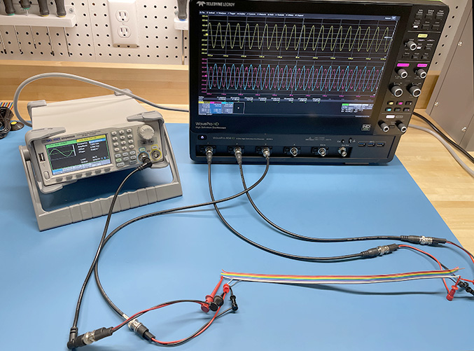 waveform generator and oscilloscope connected to a ribbon cable